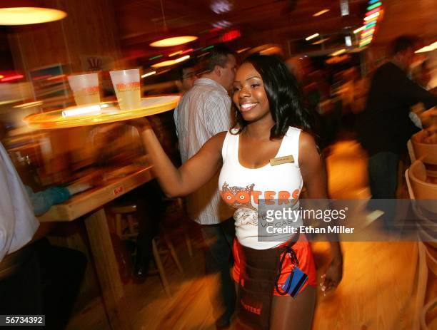 Hooters Girl Charmaine Fobbs carries drinks at the Hooters Restaurant during the grand opening of the Hooters Casino Hotel February 2, 2006 in Las...
