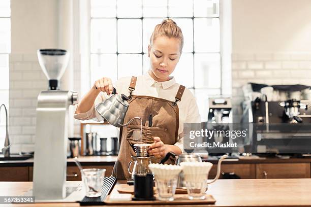 female barista preparing coffee at counter - filterkaffee stock-fotos und bilder