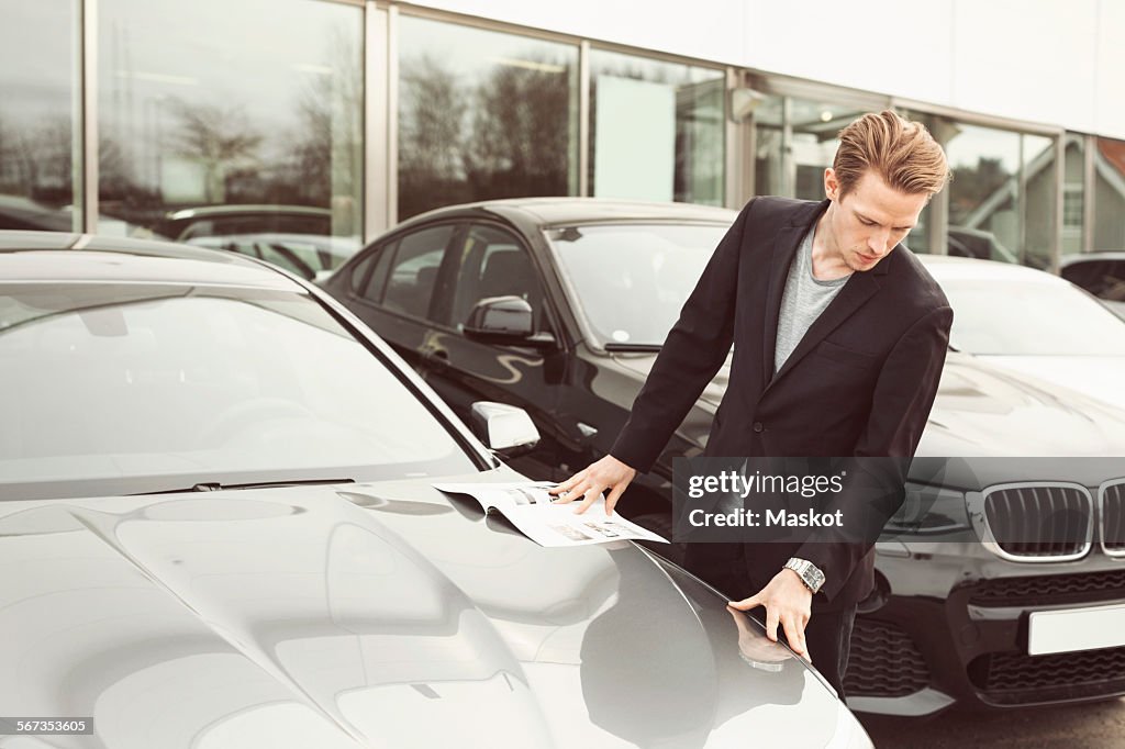 Man examining car outside showroom