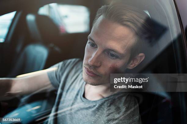 man sitting in car at dealership shop - förarsäte bildbanksfoton och bilder