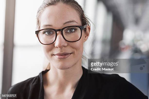 portrait of confident businesswoman in office - bril brillen en lenzen stockfoto's en -beelden