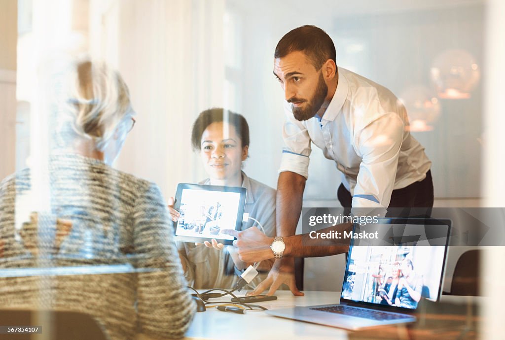 Business people giving presentation to colleague in office