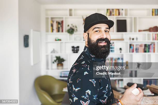 side view of portrait of happy male architect standing in home office - arab man smiling stock-fotos und bilder