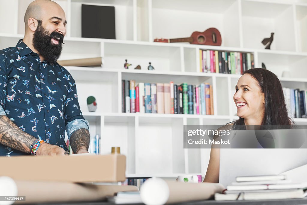 Happy male and female architects talking at home office