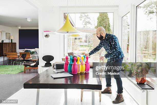 full length of male architect standing at table in home office - bowling pin stock pictures, royalty-free photos & images