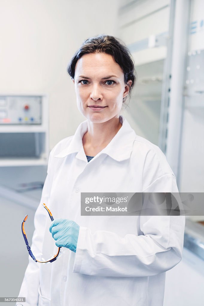 Portrait of confident female scientist standing at laboratory