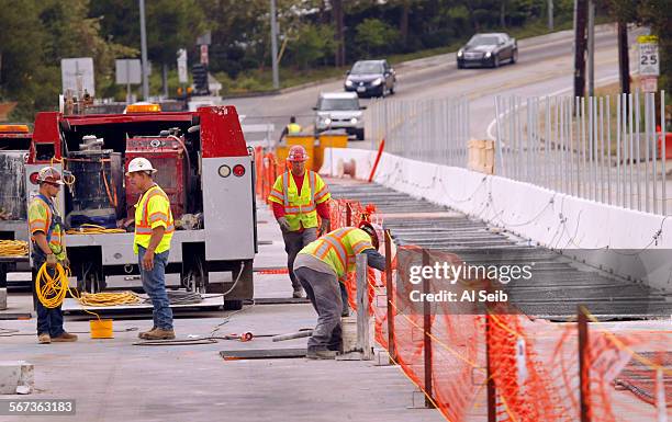Workmen continue with preparations on top of the Mulholland bridge Thursday morning for the weekend closure of the North and South bound lanes of the...