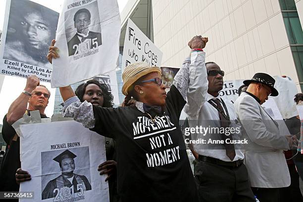 Demonstrators stand in solidarity before #BlackLives Matter members hold a press conference outside LAPD headquartes in Los Angeles after four...