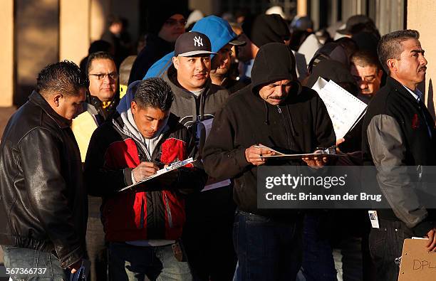 Immigrants without legal status line up to apply for California driver licenses at DMV offices January 2, 2015 in Granada Hills.