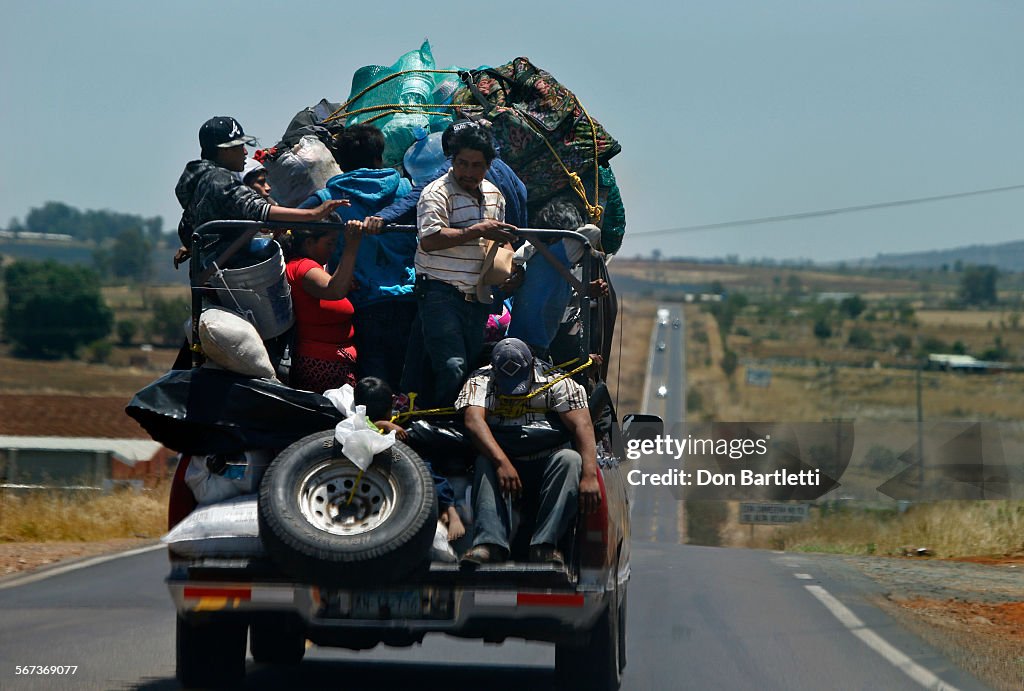 MAY 17, 2014.  GUANAJUATO, MEXICO.  With their belongings piled high on the back of a pick-up truck,