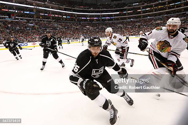 Kings defenseman Slava Voynov skates to a loose puck along with Blackhawks defenseman Nick Leddy, right, in game four of the Stanley Cup Western...