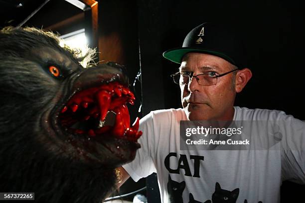 Executive producer of Halloween Horror Nights at Universal Studios Hollywood John Murdy poses with one of many werewolves during a tour of the mazes...