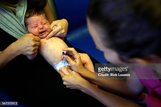 Caitlin Canelli a nursing supervisor, gives a shot to 2-month old Olive McCaffrey, of Santa Monica. Dr. Lisa Stern, a pediatrician who works in the...