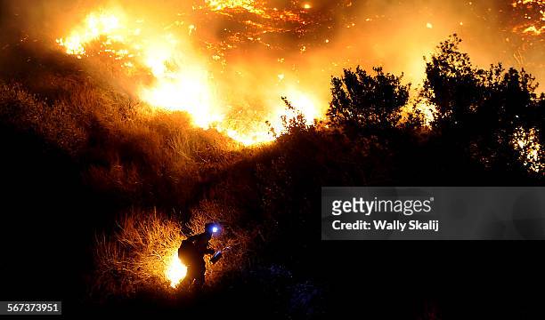 Firefighter starts a back fire along San Gabriel Canyon Road in Azusa as the Colby fire burns through brush Thursday.