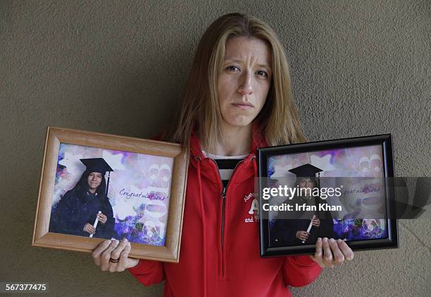 Aunt Magaly Huerta holds the photos of twins from elementary school graduation Lexandra, left, and Lexi Perez.