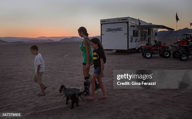 With dusk settling in, Amy Miles of Apple Valley walks with her children Kailah and Rex near the family's campsite at the Dumont Dunes on October 9,...