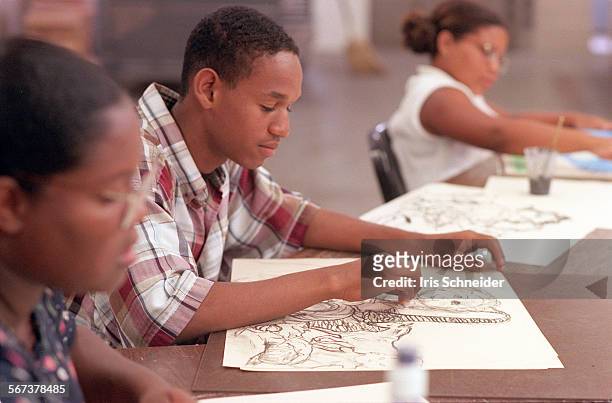 Giovanni Sheran at work on drawing at Saturday art program led by George Evans, a graphic artist for Warner Bros who grew up in Watts and now runs a...