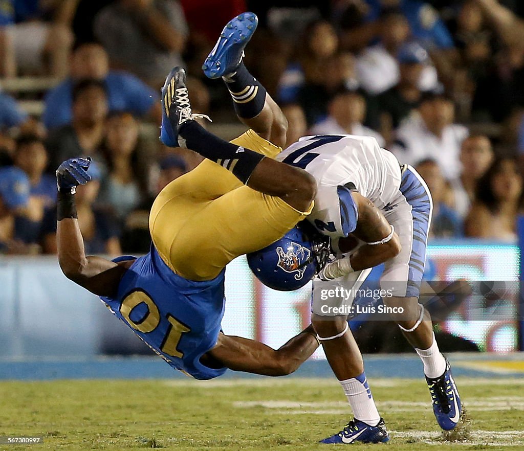 PASADENA, CLIF. - SEP. 6, 2014. UCLA defensive back Fabian Moreau, left, gets tangled up with Memphi