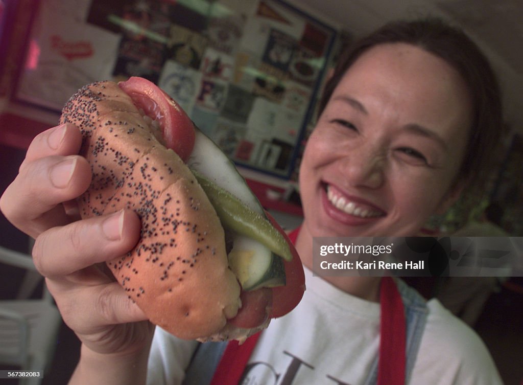 CA.Counter31.hotdog2.KRH.7/23/97.Sekyung Bae, coowner of Chicago Harv's in Fullerton with her husba