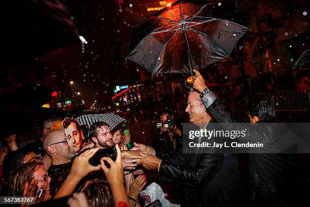 Actor Bill Murray takes photos with fans as the rain poured on the red carpet arrivals for his latest film, "St. Vincent," on the second day of the...