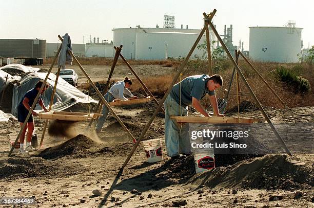 Bones1.1210.LS.Archeologists sift through dirt from a dig at the ARCO refinery in Carson, where the skeletal remains of some 50 people many of...