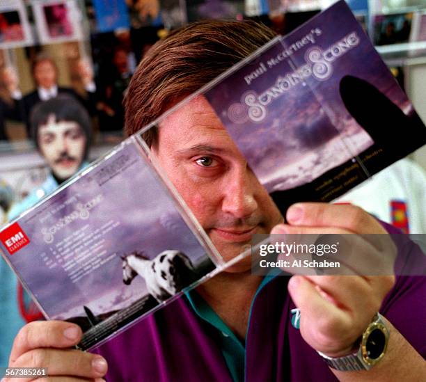 Mccartney.2.0713.ASORANGEMike Lefebvre holds Paul McCartney's "Standing Stone" compact disc and memorabilia at Pepperland Music in Orange.