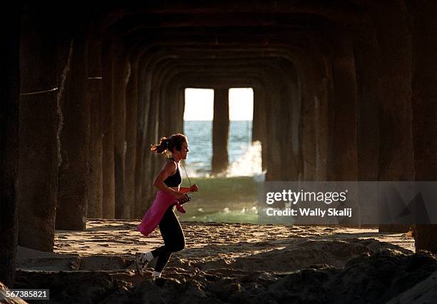 Wild Art.0414.WSA jogger runs underneath the Manhattan Beach Pier on a sunny spring afternoon Monday, April 13, 1998.Photo/Art by:^^^