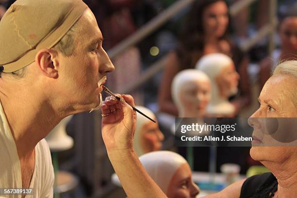 Makeup artist Nancy Remley, right, paints Chris Martin's face backstage, before performing in Rembrandt van Rijn's painting "The Night Watch"during a...
