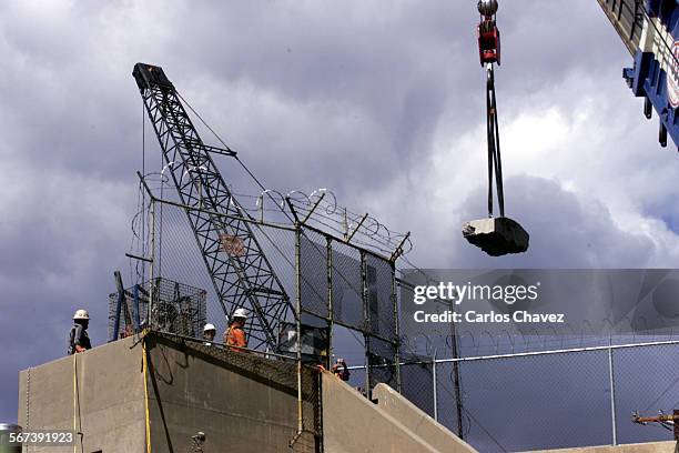 Secretary of the Interior, Bruce Babbit, manned the controlls of a crane that lifted a 16,000pound slab of concrete from the face of the 200ft....