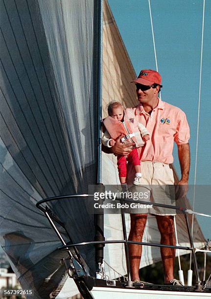 Sailfashion.polo.4.BG.12Feb98John Marston holds his daughter Amanda on the bow of a sailboat making its way up Newport Harbor wearing LW regatta...