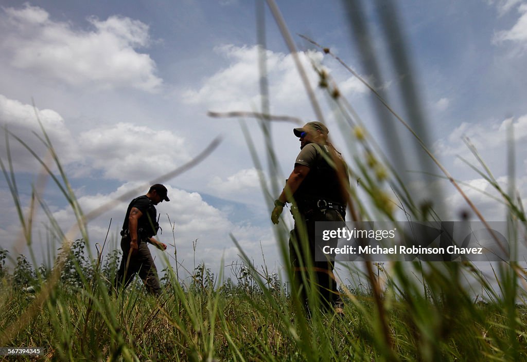 FALFURRIAS, TEXAS-JULY 17, 2014:  Brooks County deputies Daniel Zamarripa, right, and Domingo Aguirr