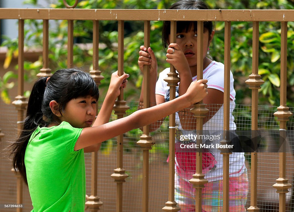 LOS ANGELES, CALIFORNIA, AUGUST 11, 2014: Children watch while work  to remove soil from the front a