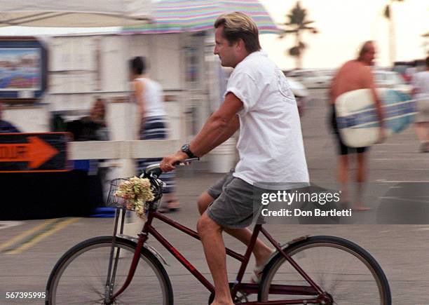 Fair.Labok.DB.090498.HuntingtonBeach.  Bruce Labok pedals along Walnut Ave on his old bike with a basket of tuber roses. The local resident says...
