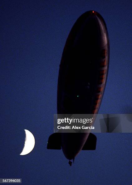Goodyear Blimp passes by the moon while - Main Image