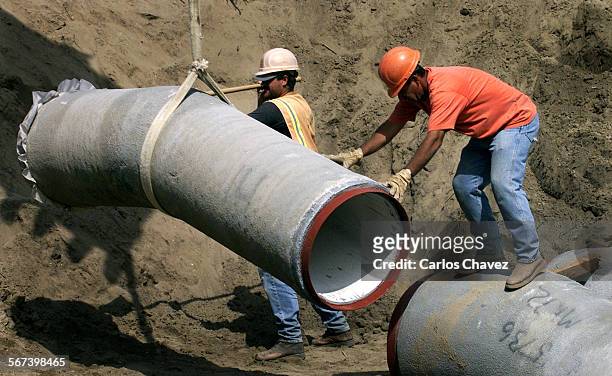 Construction workers lineup one of the elbows of a water line for the Camrosa Water District's water diverion plant along the Calleguas Creek. The...