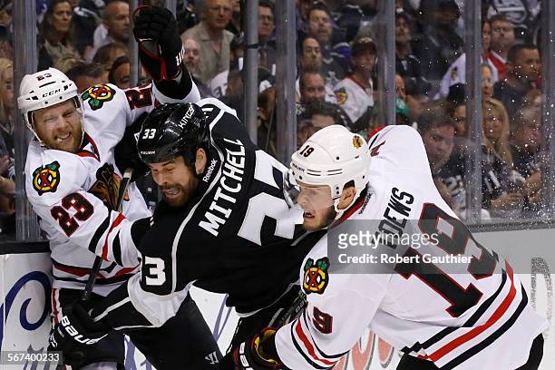 Kings defenseman Willie Mitchell is sandwiched between Blackhawks forwards Kris Versteeg, left, and Jonathan Toews during second quarter action in...