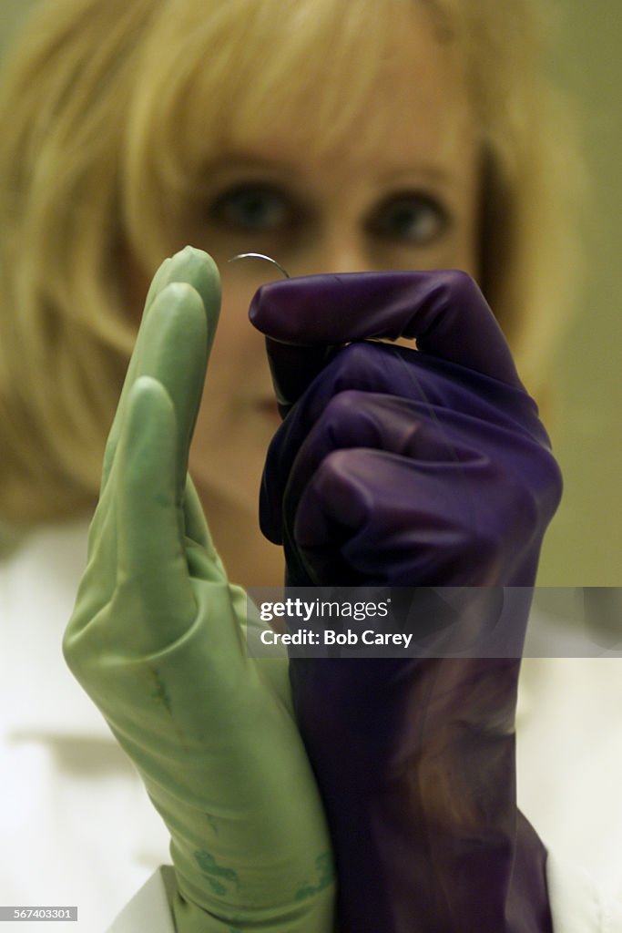Robin Beck, president of Bio Barrier, wears two of her latex gloves and holds a surgical needle. Her
