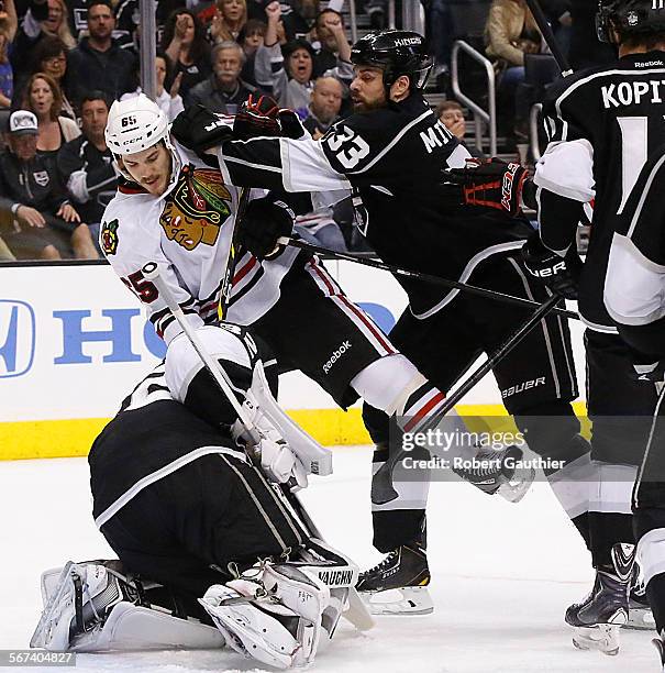 Kings defenseman Willie Mitchell shoves Blackhawks forward Andrew Shaw away from goalie Jonathan Quick in game three of the Stanley Cup Western...