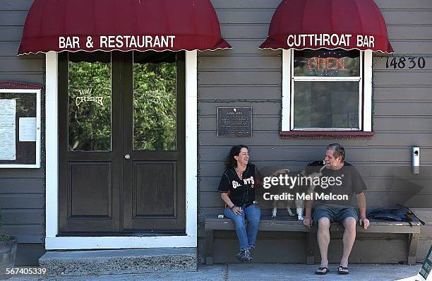 Bartender Danea McAvoy left, enjoys a break from work with a man who identified himself as Buz, a chef, and his border collie named Annie Oakley,...