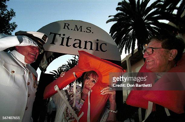 Islanders.Titanic.0824.DBNewportBeach.  "Captain" Dick Stevens of Newport B. Greets arriving guests Harriett and Irv Wieder of Huntington Beach...