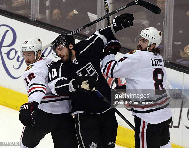 Los Angeles Kings center Mike Richards is sandwiched between Chicago Blackhawks center Marcus Kruger and Chicago Blackhawks defenseman Nick Leddy...