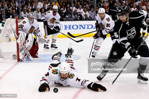 Blackhawks defenseman Brent Seabrook dives to the puck after losing his stick during an offensive surge from Kings defenseman Slava Voynov during...