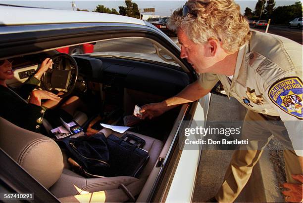 Carpool.Frey.DB.102198FountainValley California Highway Patrol officer Andre Frey inspects license of a motorist he pulled over for driving alone...