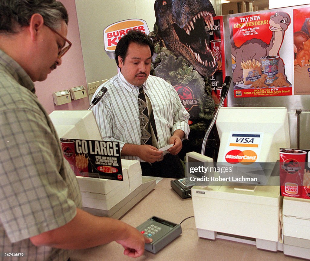 FI.Mcdon.Credit.RDL (kodak) (52097) At Burger King in Tustin , (left) Rick Millan of Tustin uses a