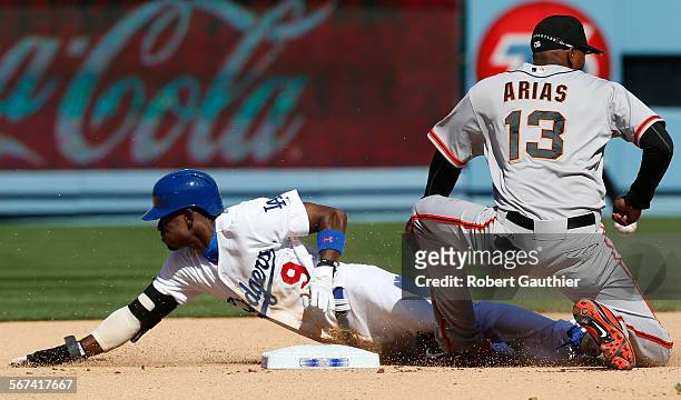 Dee Gordon slides safely past the tag of Giants shortstop Joaquin Arias for stolen base in the sixth inning at Dodger Stadium.