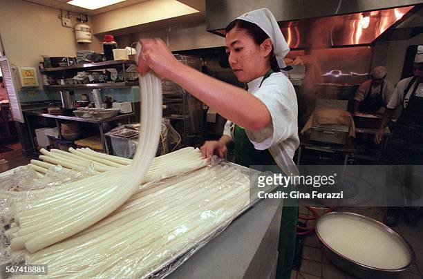 Ox.4.0207.GFYumi Yang pulls rice cakes apart before they are chopped up at San Su Jang rice cake shop in Los Angeles. Rice cakes are important in the...