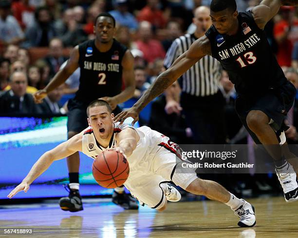 Arizona guard TJ McConnell dives between SDSU teammates Xavier Thames, left, and Winston Shepard to steal the ball late in the second half, to help...