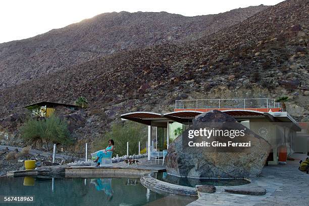 Homeowner Liz Ostoich with her dog Reilly sits next the infinity pool at her 1959 midcentury modern cliffside home on January 29, 2014 in Palm...