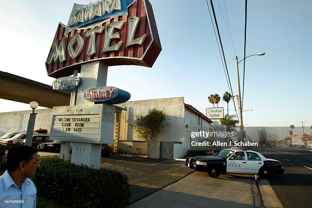 ANAHEIM, CA-MARCH 18, 2014: Naresh Patel, left, owner of Sahara Motel, watches an Anaheim Police cru