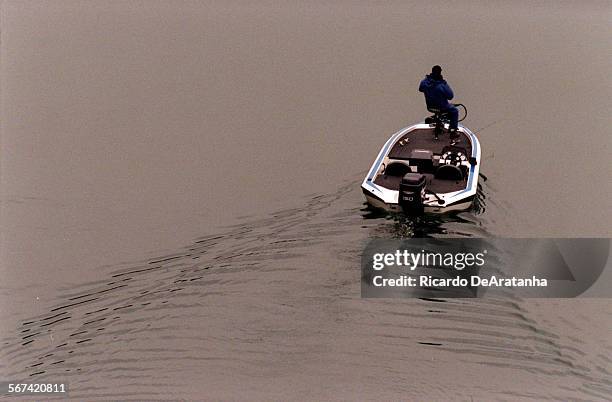 Friday, 3/3/2000  Fisherman's boat leaves a wake on the glassy water of Lake Piru.